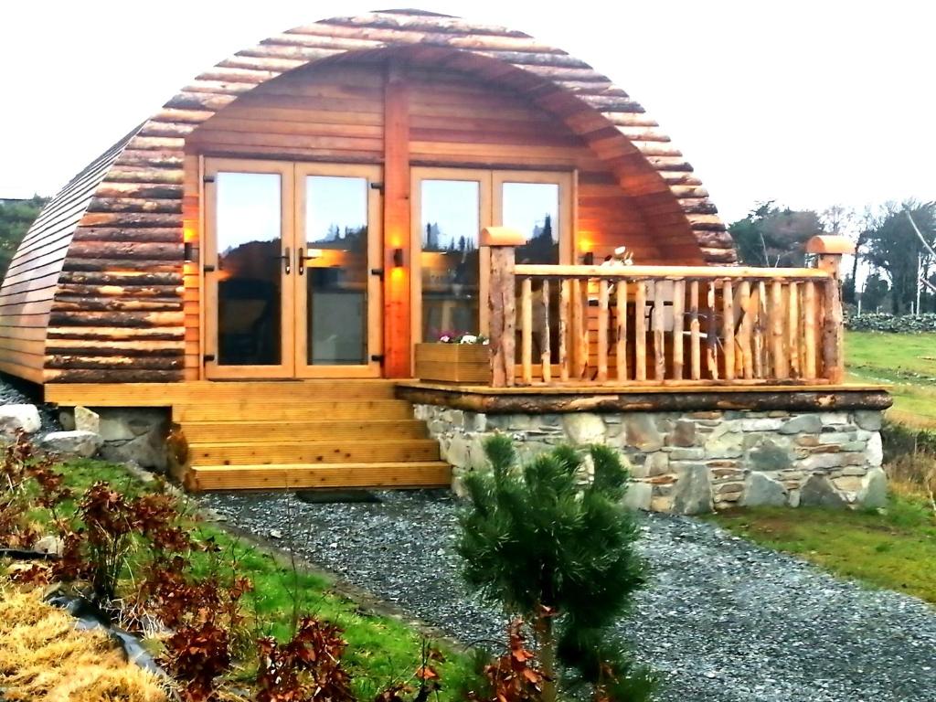 een blokhut met een veranda en een terras bij Tollymore Luxury log cabins in Newry