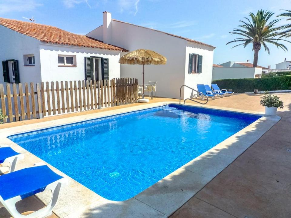 a swimming pool in front of a house at Villa Ferrer in Port d'Addaia