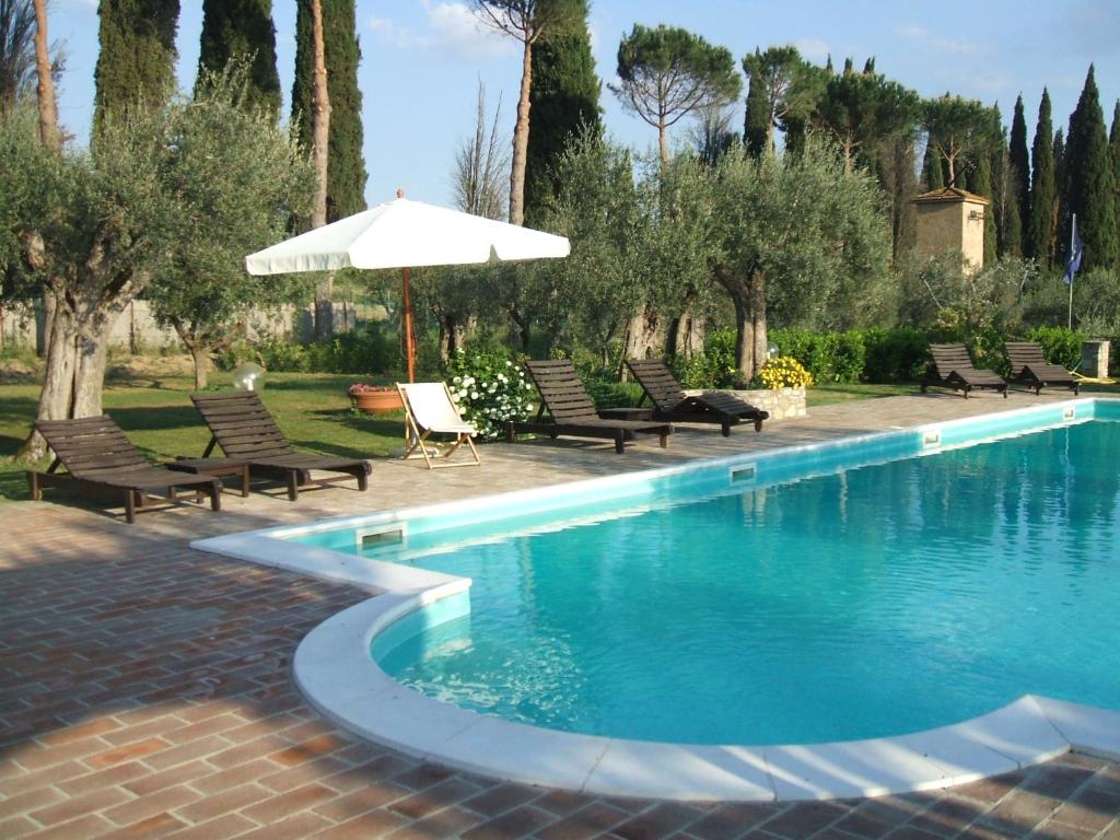 een zwembad met stoelen en een parasol bij Ryan Apartment in Passignano sul Trasimeno