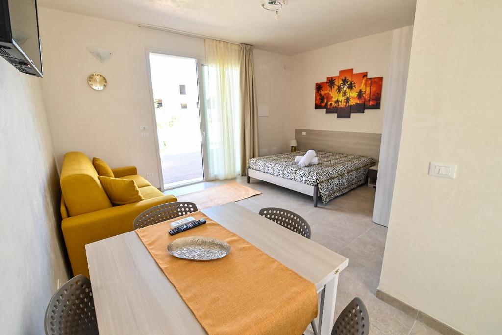 un soggiorno con tavolo e divano giallo di ARIA D'ORIENTE a Uggiano la Chiesa