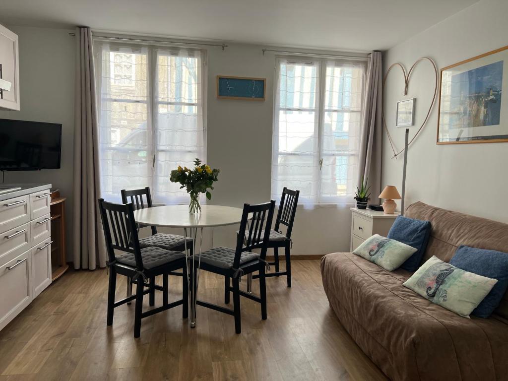 un salon avec une table, des chaises et un canapé dans l'établissement LE PASTEL, à Honfleur