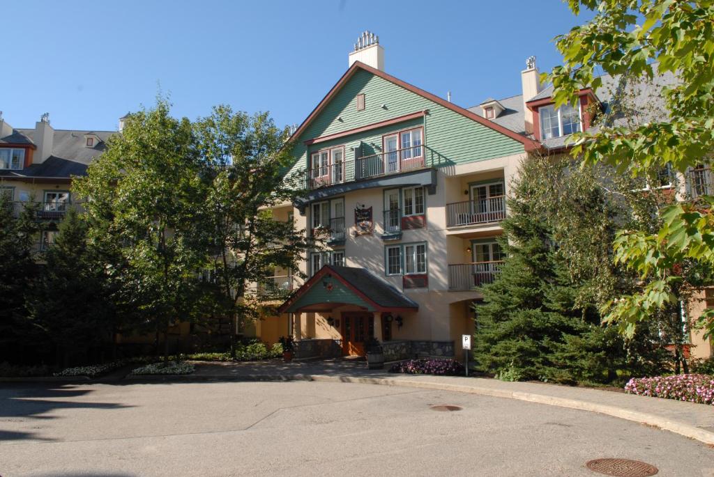 a large apartment building with a green roof at Lodge de la Montagne in Mont-Tremblant