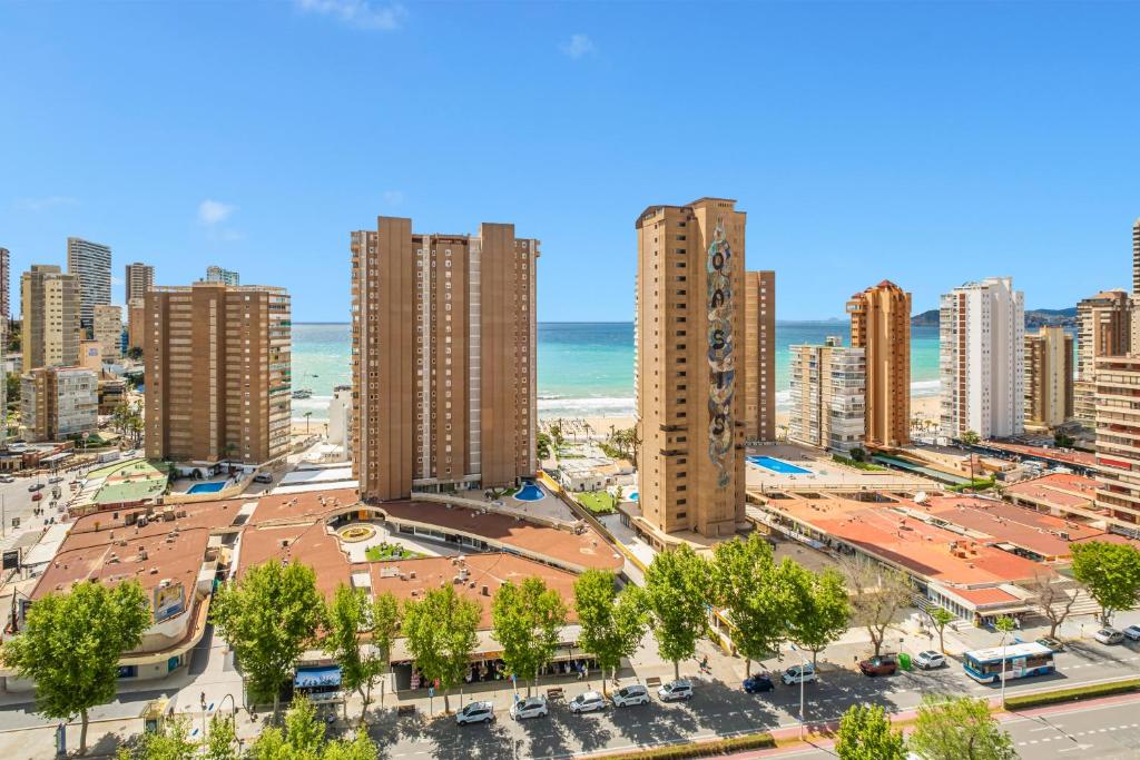 une vue aérienne sur une ville avec de grands bâtiments et l'océan dans l'établissement Albatros 18-8, à Benidorm