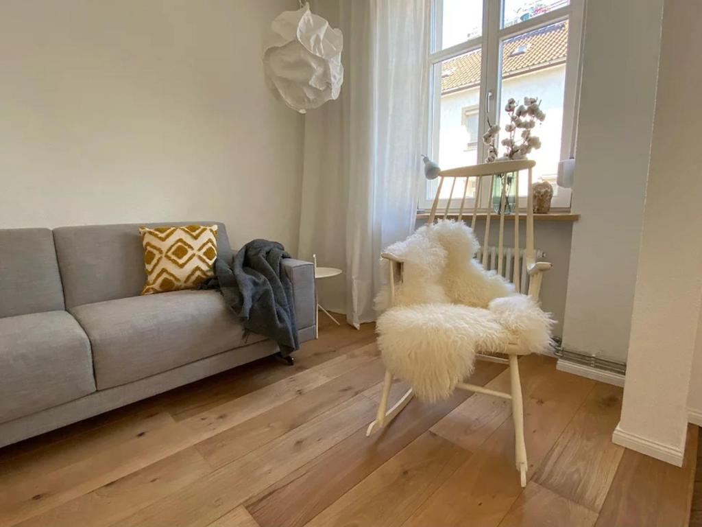 a living room with a couch and a white chair at annadaly Stadtraumwohnung in Lörrach