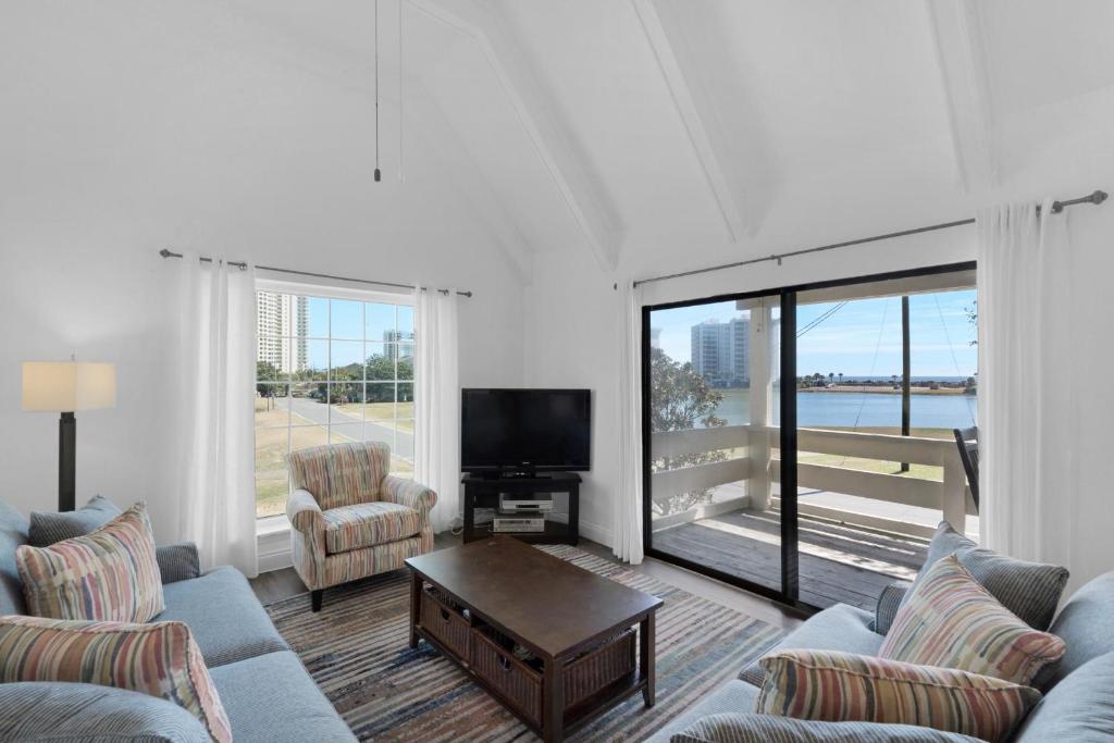 ein Wohnzimmer mit Sofas, einem TV und einem großen Fenster in der Unterkunft Beachy Keen in Destin