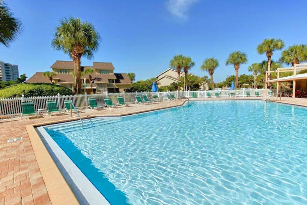 ein großer Swimmingpool mit Stühlen und Palmen in der Unterkunft Beachy Keen in Destin