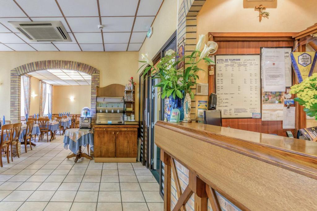 a restaurant with a counter and tables and chairs at Hotel Acapulco in Lourdes