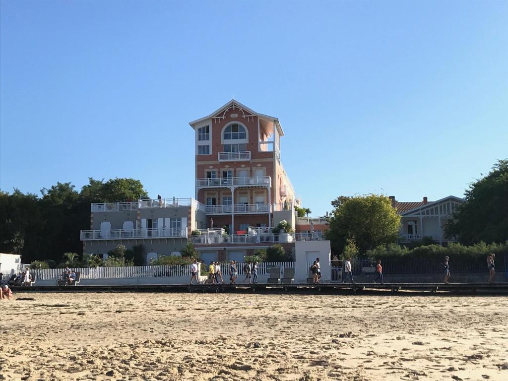 - un bâtiment sur la plage à côté d'une plage de sable dans l'établissement Appartement T4 8 personnes 1ère ligne Bassin d'Arcachon, à Arcachon