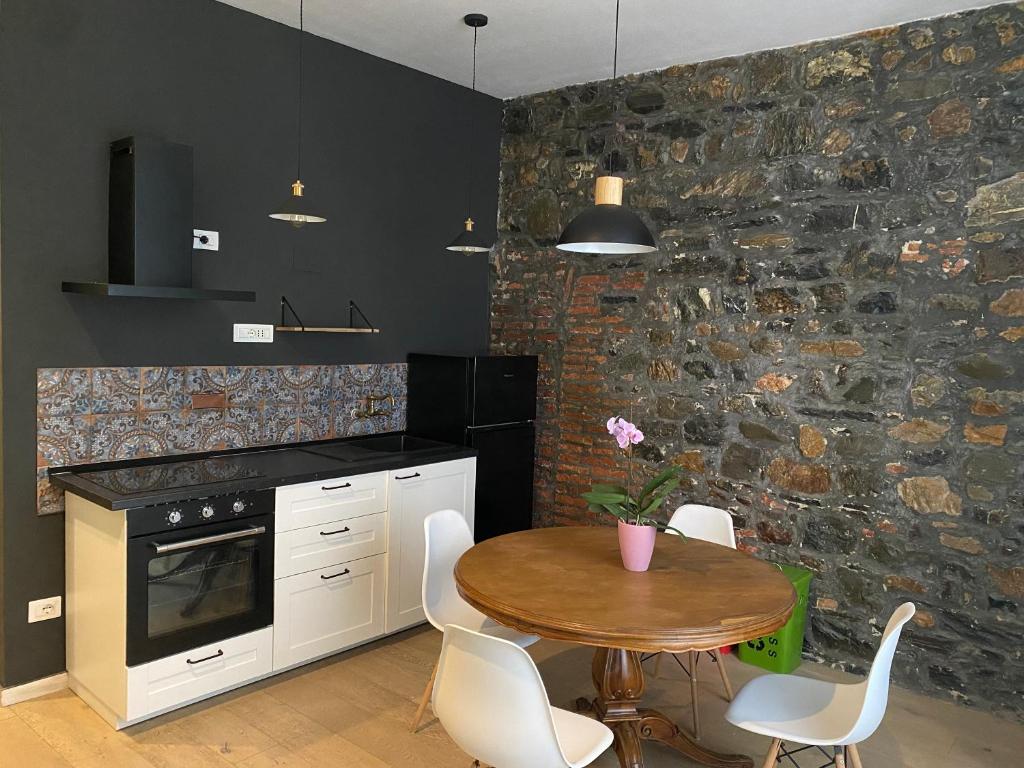 a kitchen with a table and a stone wall at La Chicca del Centro in La Spezia