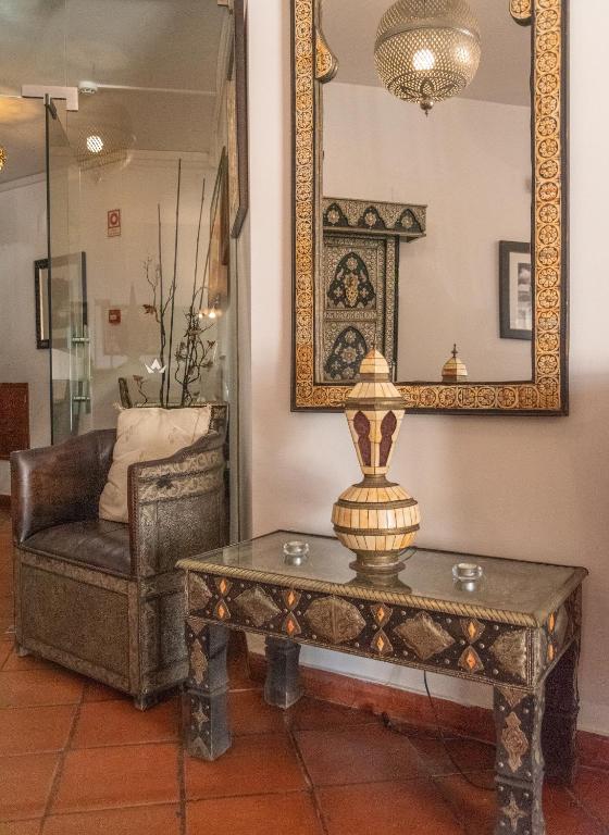 a living room with a table and a chair at Hotel Vale Da Telha in Aljezur