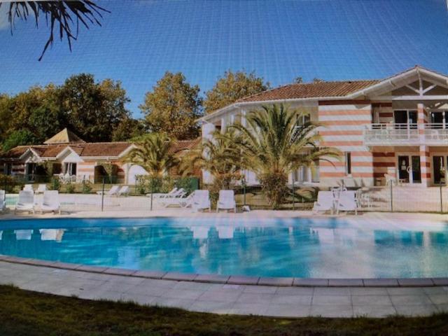 uma grande piscina em frente a uma casa em Résidence domaine des sables ROUTE 66 em Soulac-sur-Mer
