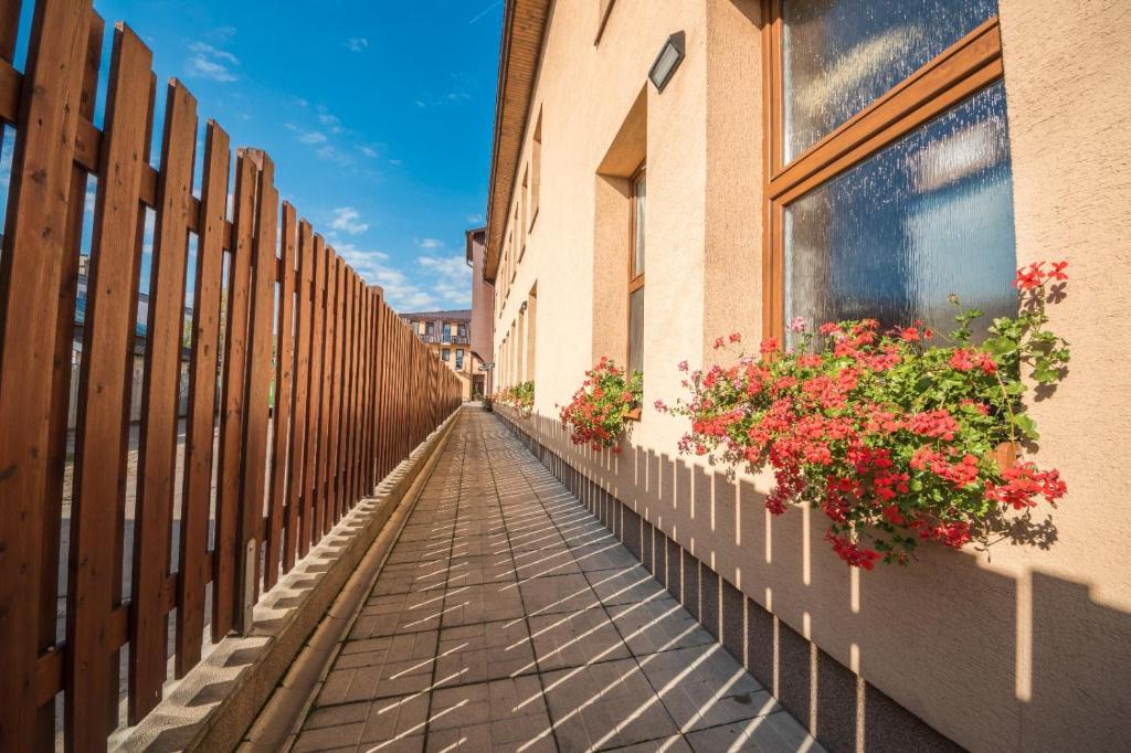 a street with flowers on the side of a building at Penzión Radlinka in Prešov