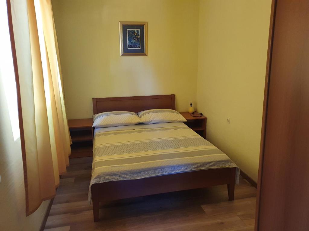 um pequeno quarto com uma cama com duas almofadas em Country House Iva em Trbounje