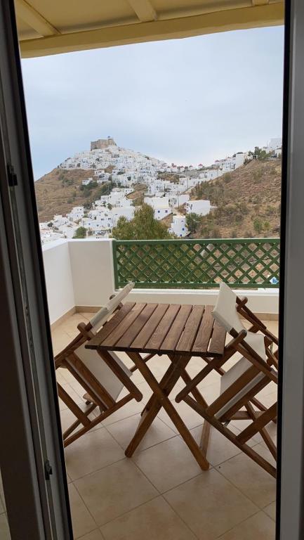 a wooden table and chair on a balcony with a view at Theasis apartment in Pera Gyalos