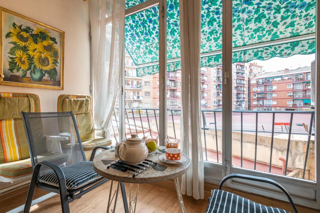 バルセロナにあるFlat Meridianaのテーブルと椅子、大きな窓が備わる客室です。