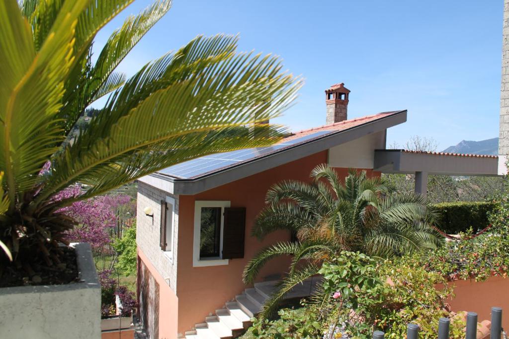 una casa con palmeras delante en Villino con piscina, en Terni