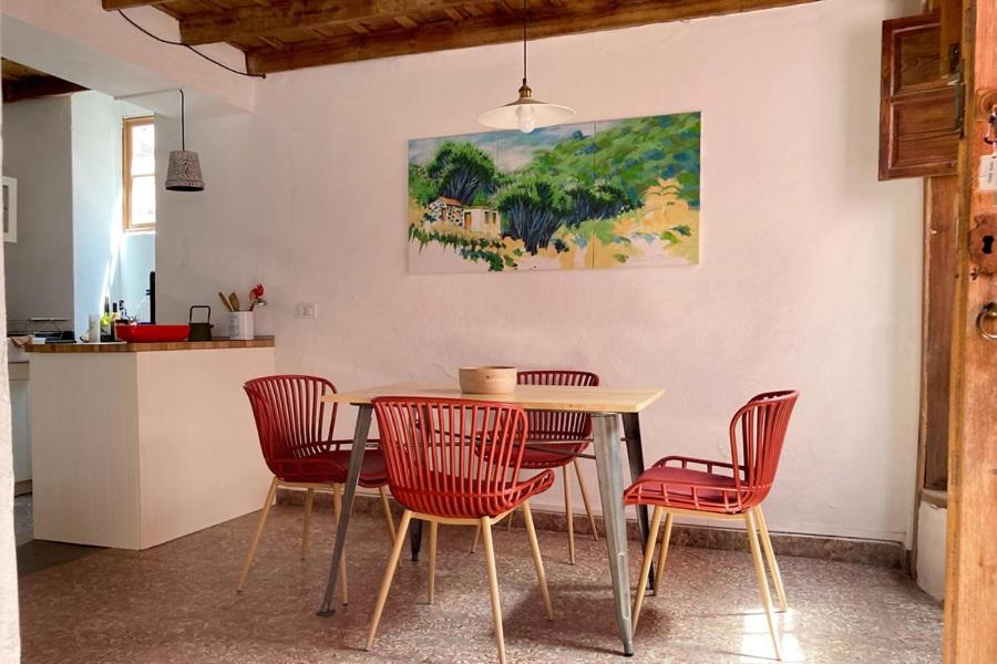 a dining room with a table and red chairs at Casa Trigo in Tazacorte