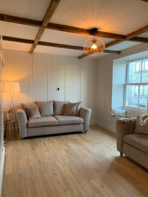 een woonkamer met een bank en een lamp bij Cosy 1st floor Flat - Kendal Lake District with bike storage in Kendal