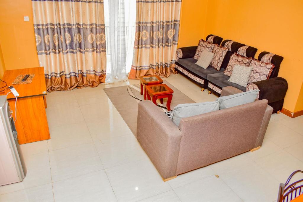 een woonkamer met een bank en een tafel bij Almasi Place in Nairobi