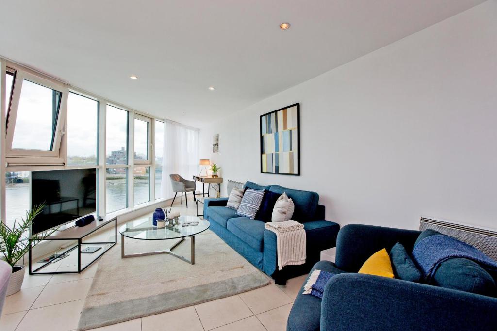 a living room with blue couches and a tv at River views in London