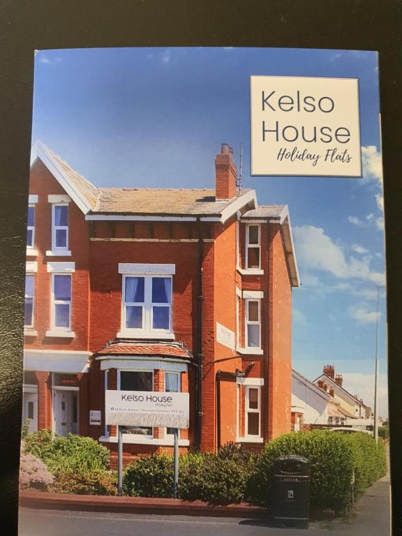 a brick house with a sign in front of it at Kelso House holiday flats in Blackpool
