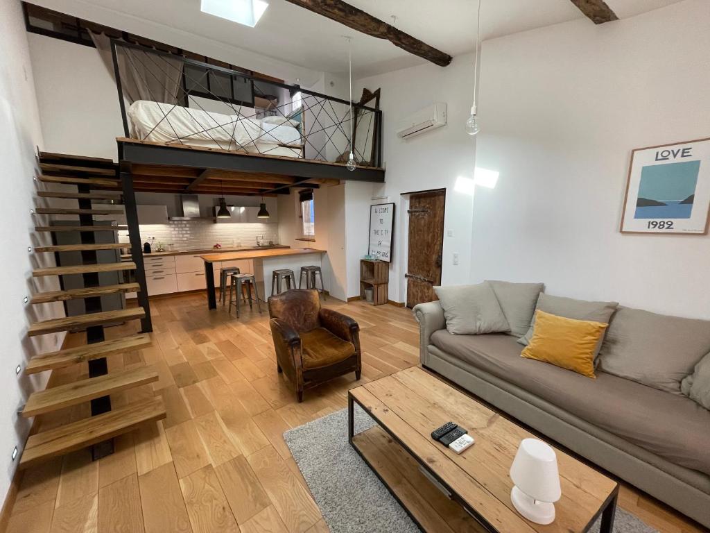un salon avec un canapé et une mezzanine dans l'établissement duplex avec vue sur les arènes, à Arles