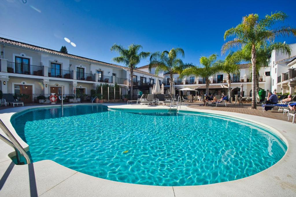 馬貝拉的住宿－Paloma Blanca Boutique Hotel- Adults Recommended，大楼前方的蓝色海水大型游泳池