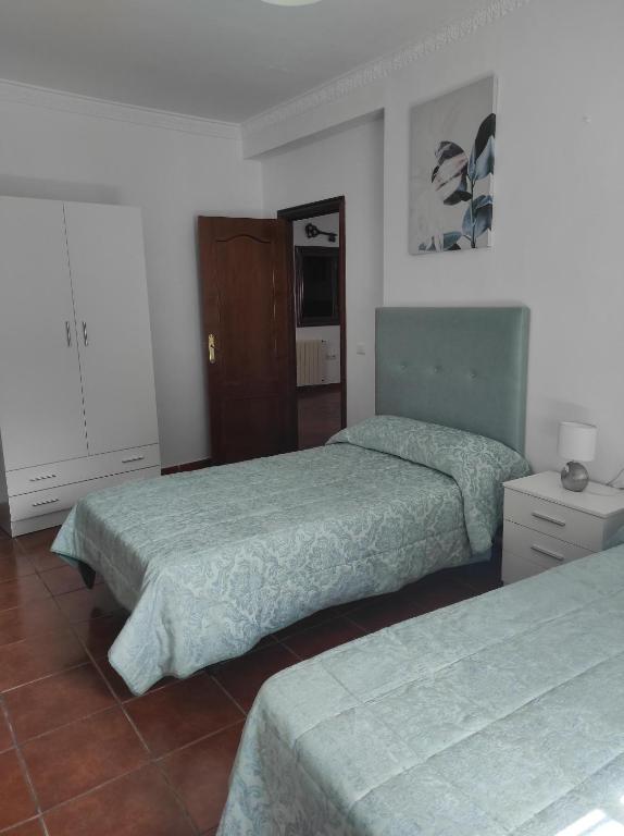Habitación de hotel con 2 camas y espejo en Casa Rural Moreno en Setenil