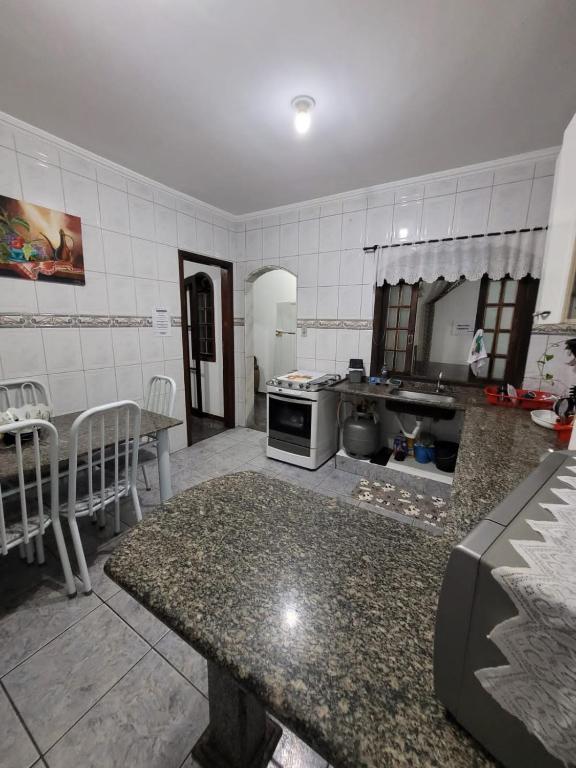 a kitchen with a table and a counter top at Casa Grande para Família e Amigos in São Lourenço