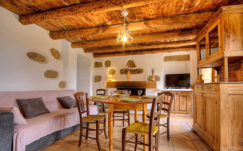 Il comprend une cuisine et un salon avec une table et des chaises. dans l'établissement Gîte à Piscia de Figari Petru Barbara, à Figari