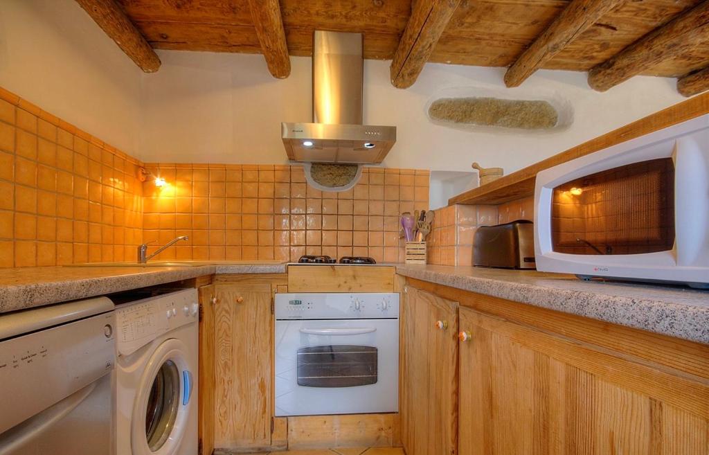 a kitchen with a washer and dryer and a microwave at Gîte à Piscia de Figari Petru Barbara in Figari