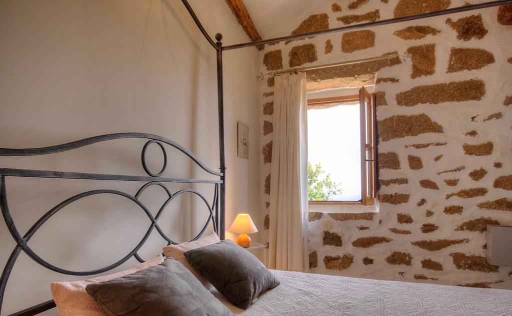 a bedroom with a metal bed with a window at Gîte à Piscia de Figari Petru Barbara in Figari