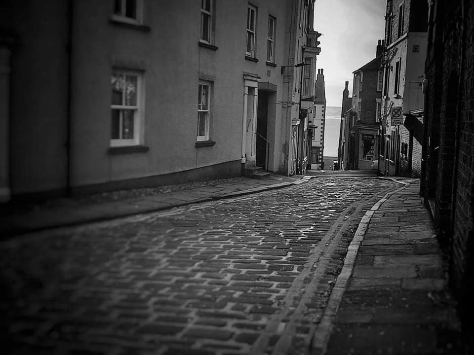 a black and white photo of a cobblestone street at Haddock Hideaway by the Sea in Scarborough