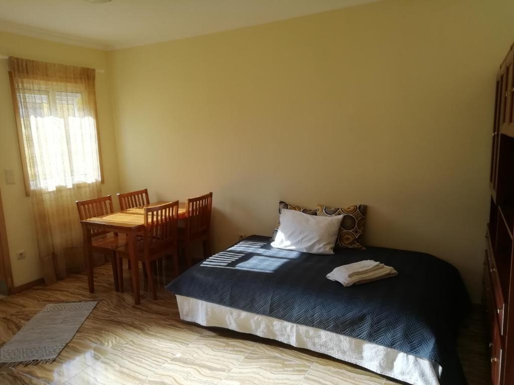 a bedroom with a bed and a table with chairs at Al Gaia Centro Historico in Vila Nova de Gaia