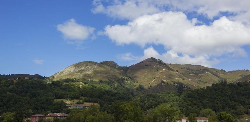 a view of a mountain range with trees and houses at Casa La Cruz a 2km de Cangas de Onís in Cangas de Onís