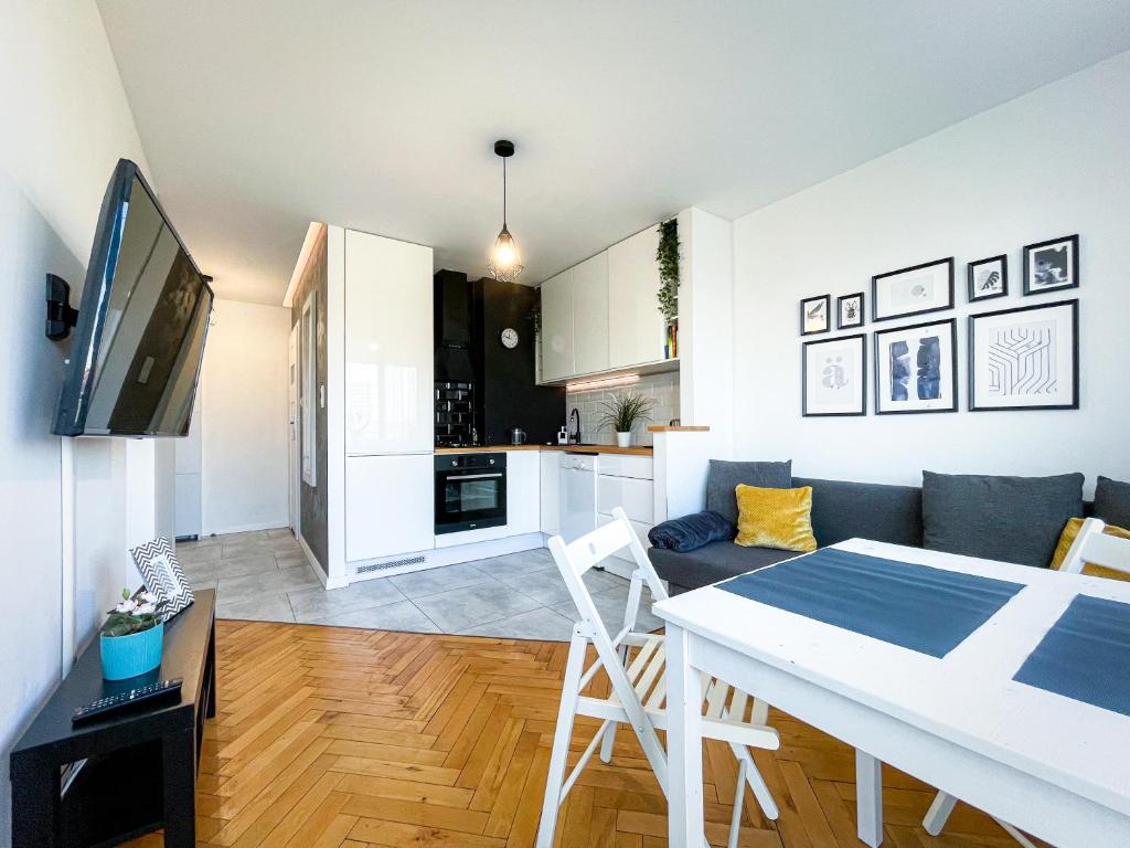 a kitchen and living room with a table and a couch at COCO Apartments Jagiellońska 10 in Gdańsk