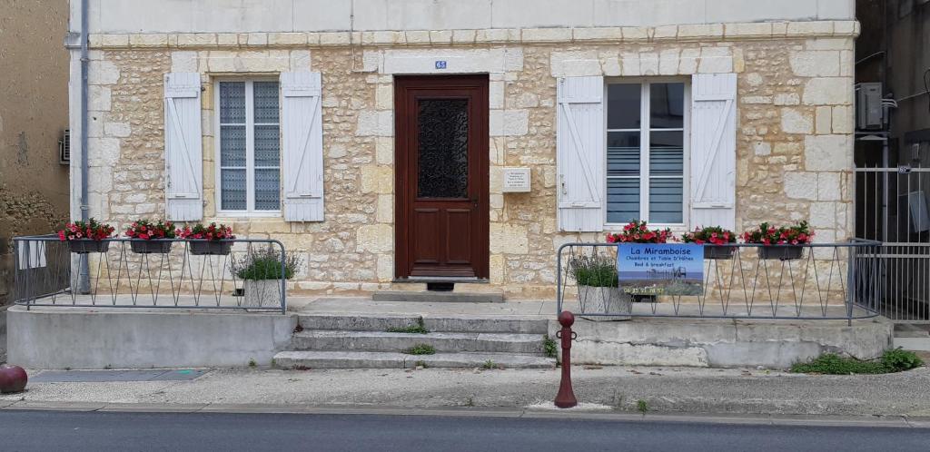 un edificio con fiori davanti ad una porta di La Miramboise, chambres et table d hôtes a Mirambeau