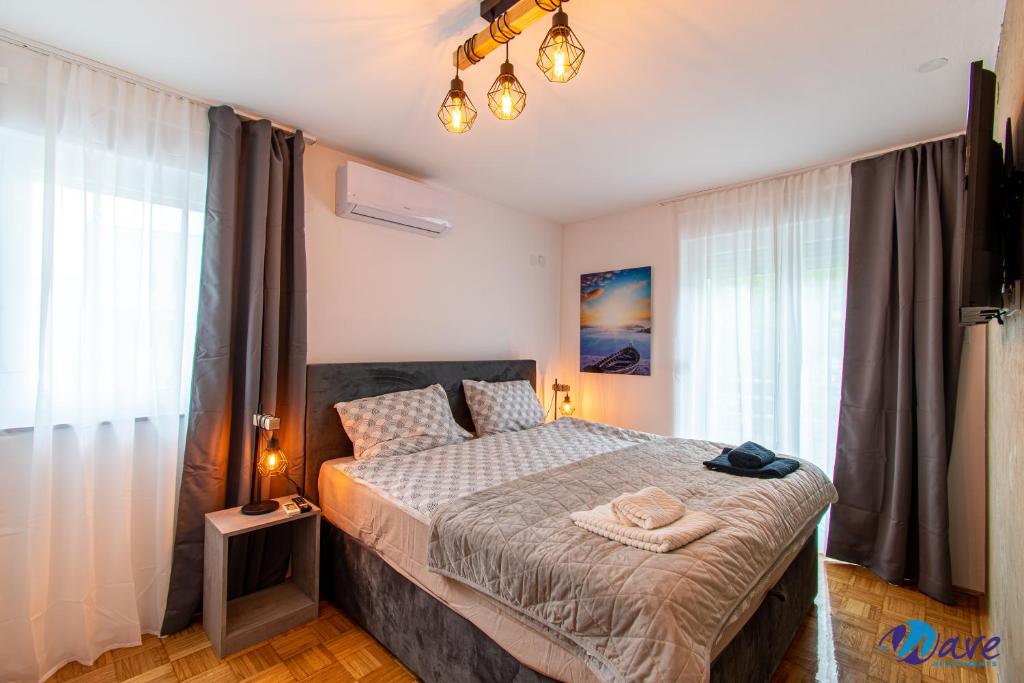 a bedroom with a large bed in a room with windows at TWO BEDROOM MODERN APARTMENT near the AIRPORT in Velika Gorica