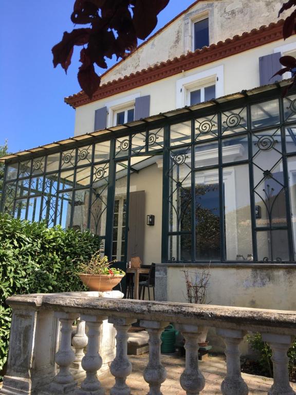 een groot glazen gebouw met een hek ervoor bij LaFabriek in Canet d'Aude