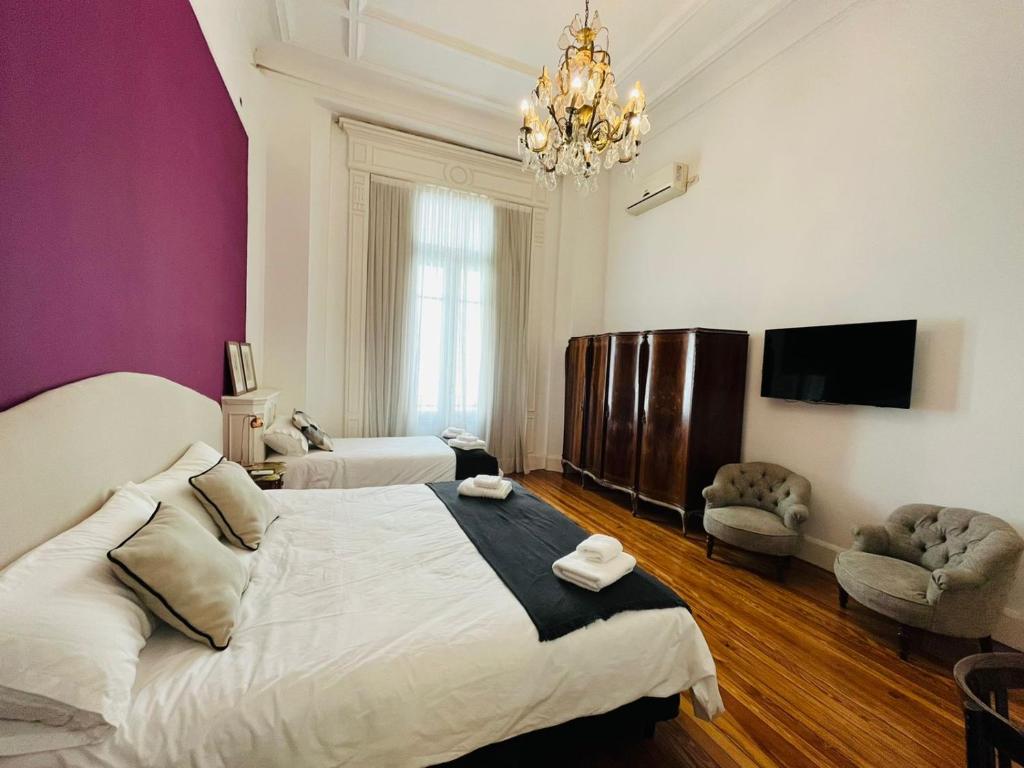 Un dormitorio con una cama grande y una lámpara de araña. en Hotel Chemin en Buenos Aires