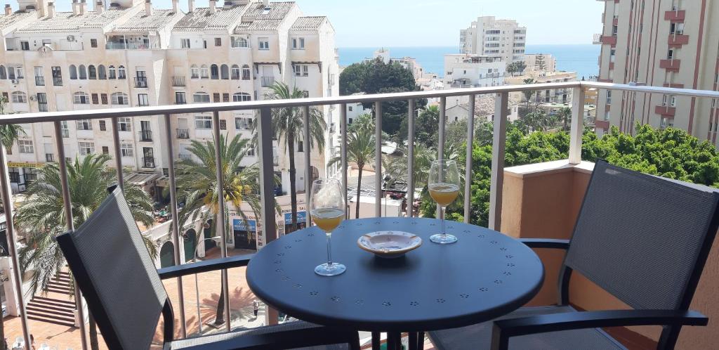 a table with two glasses of wine on a balcony at Minerva Paradise in Benalmádena