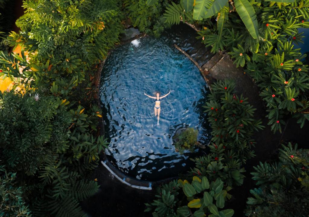 um homem parado no meio de uma piscina de água em Montaña de Fuego All Inclusive em La Fortuna