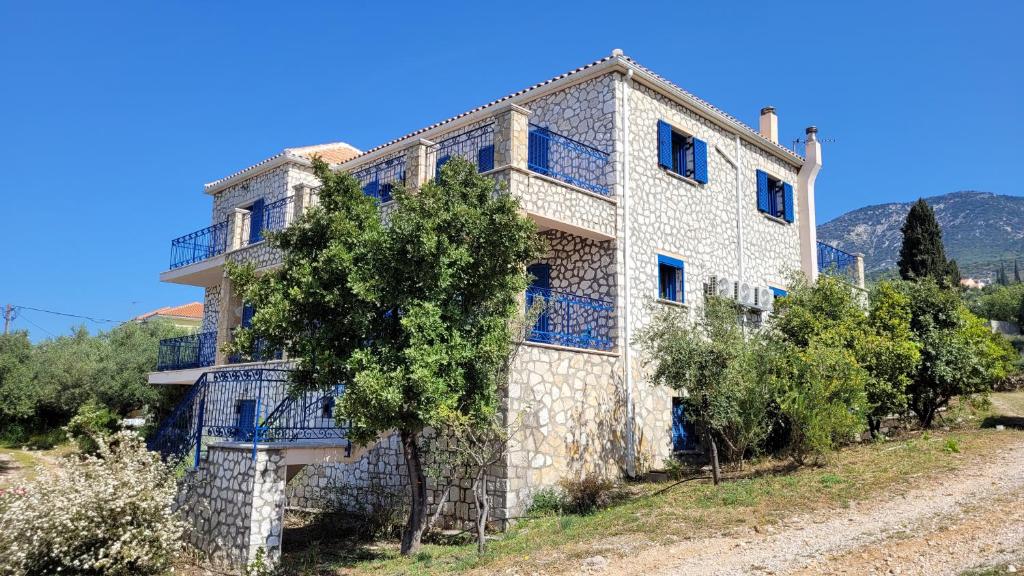 a large stone building with trees in front of it at Stone House in olive Grove - former Denis Stone Villa in Trapezaki