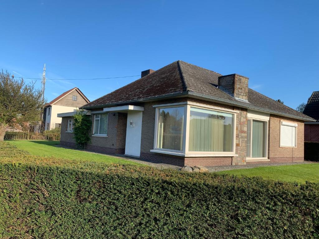 a house with a large window in a yard at De Lelie in Achel