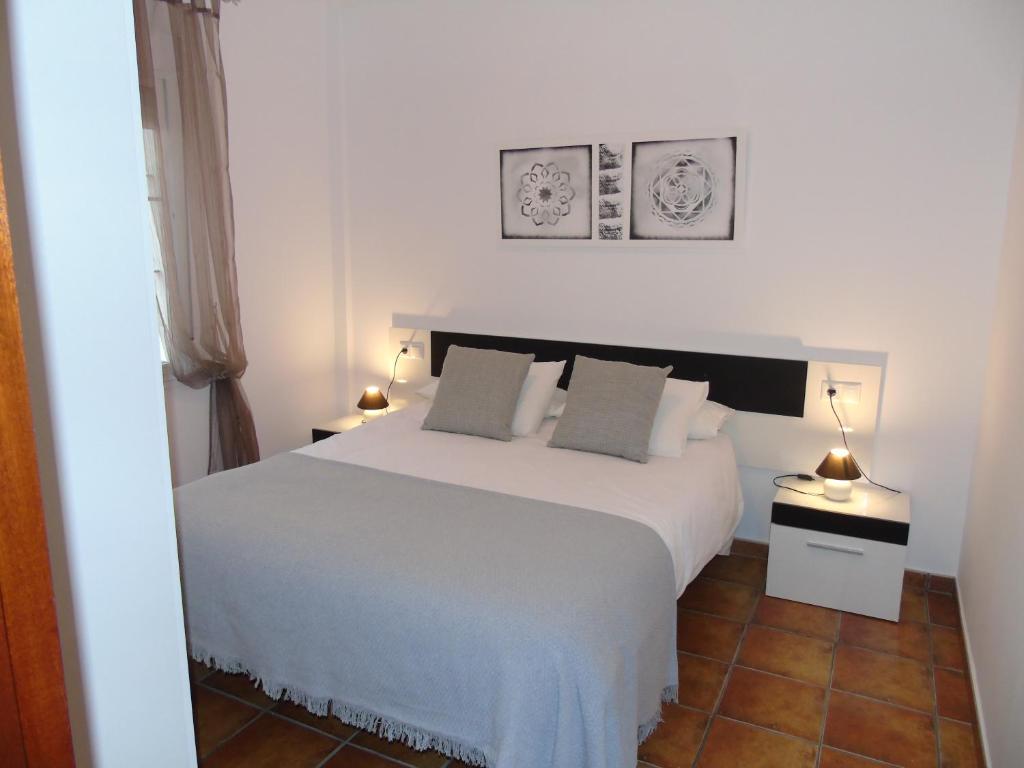 a bedroom with a white bed and two lamps at Atiko La Vista in Arcos de la Frontera