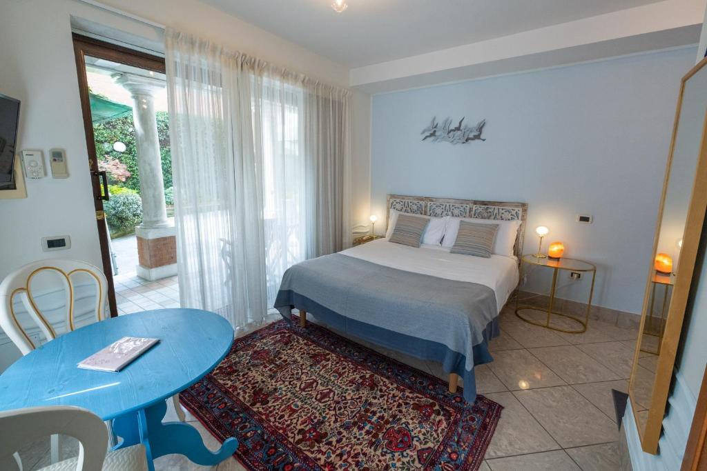 a bedroom with a bed and a blue table and a table at Casa di Carlo Goldoni - Dimora Storica in Chioggia