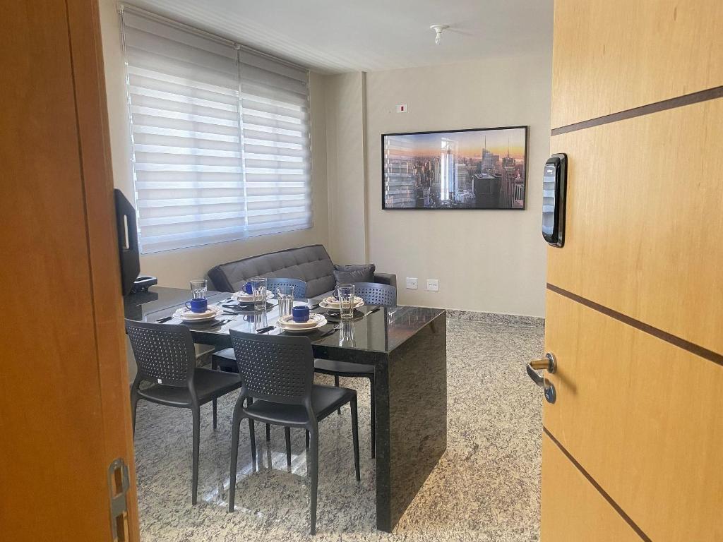 um quarto com uma mesa e cadeiras e um sofá em Locking´s Santo Agostinho 7 - Apto 2 quartos novo ao lado Diamond Mall em Belo Horizonte