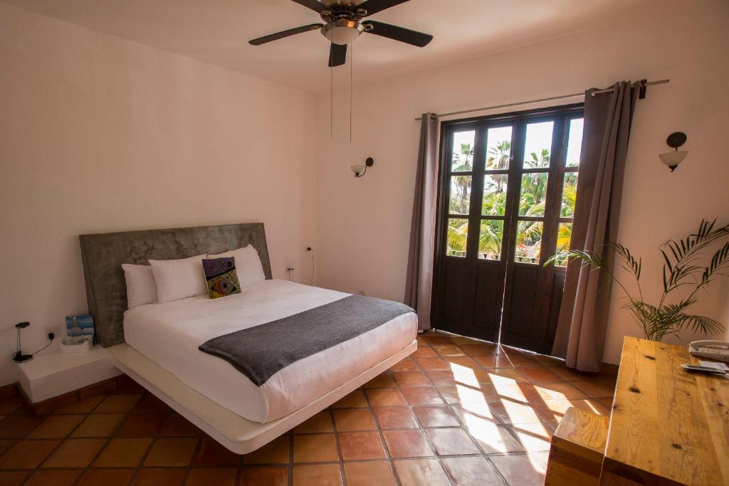 a bedroom with a bed and a ceiling fan at Hotel Casa Tota in Todos Santos