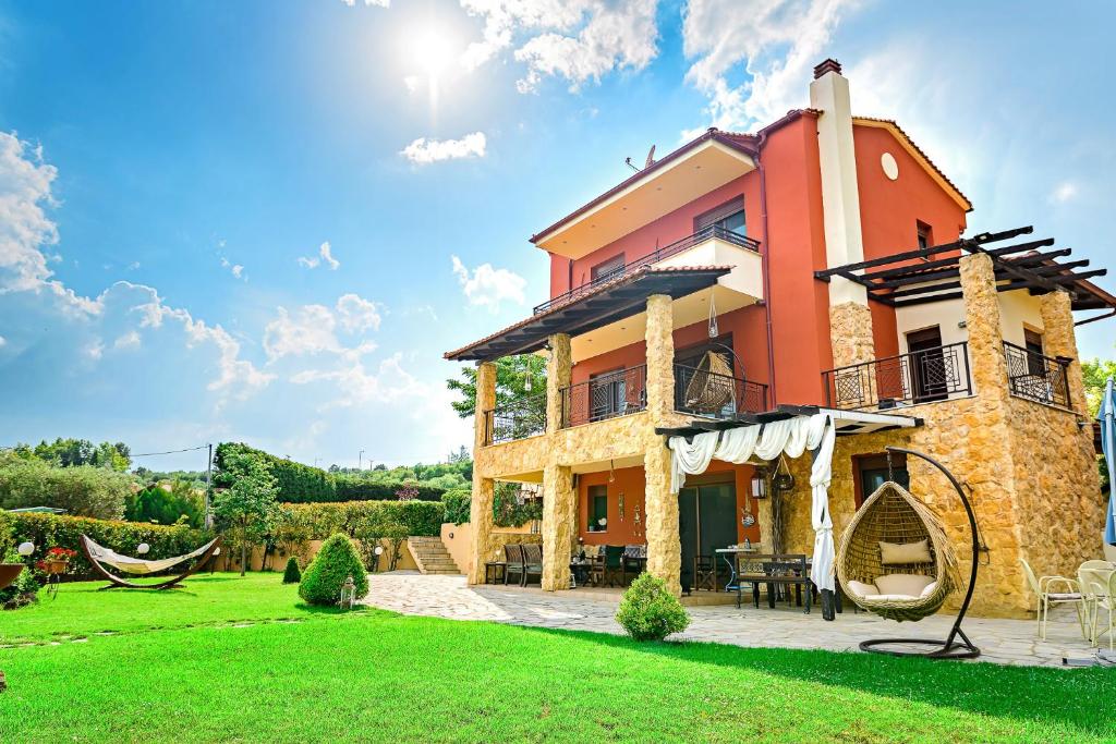 uma villa com um quintal e uma casa em Villa Mariellie em Nea Peramos