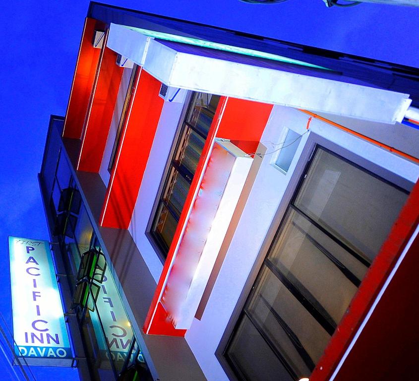 a red and white building with a blue at First Pacific Inn Davao in Davao City
